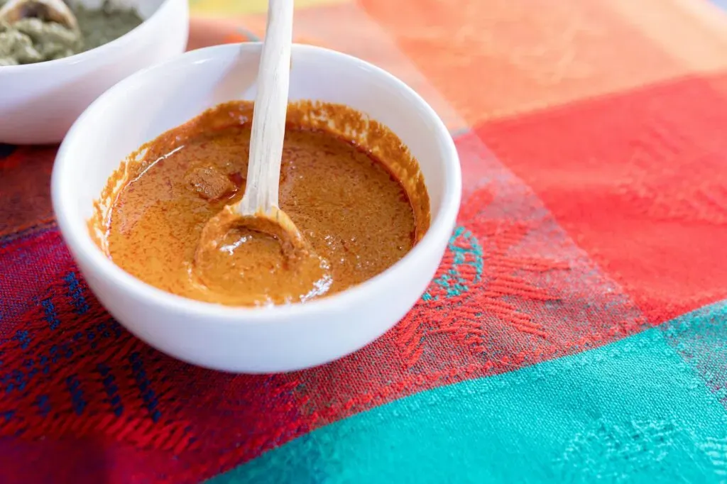 Mole amarillo oaxaqueño servido en bowl sobre mantel tradicional