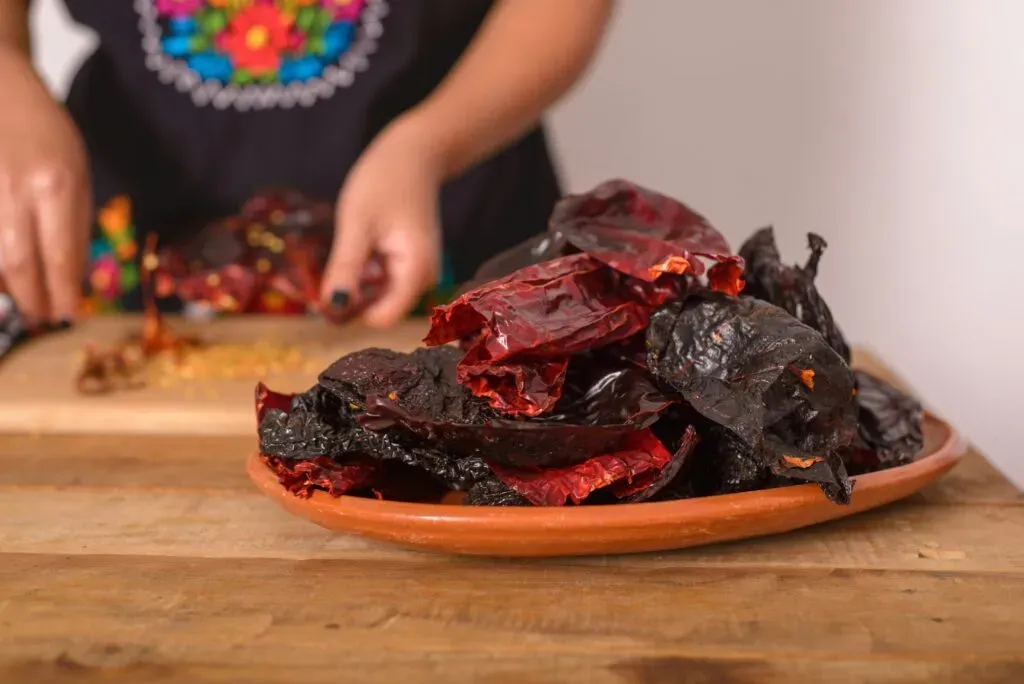 Chiles ancho y guajillo en plato de barro para preparar salsa oaxaqueña