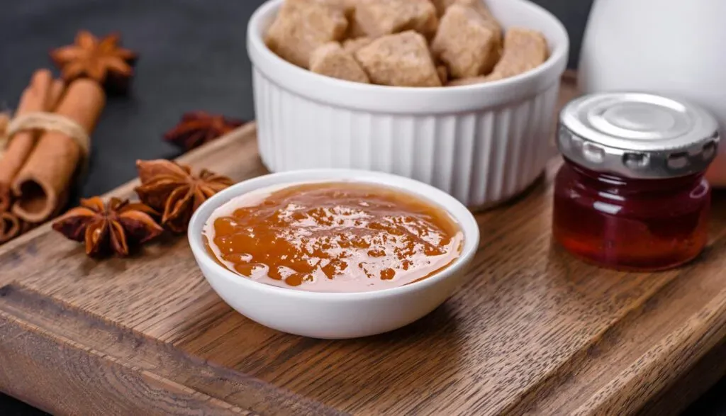 Dulce de leche artesanal con azúcar sobre tabla de madera