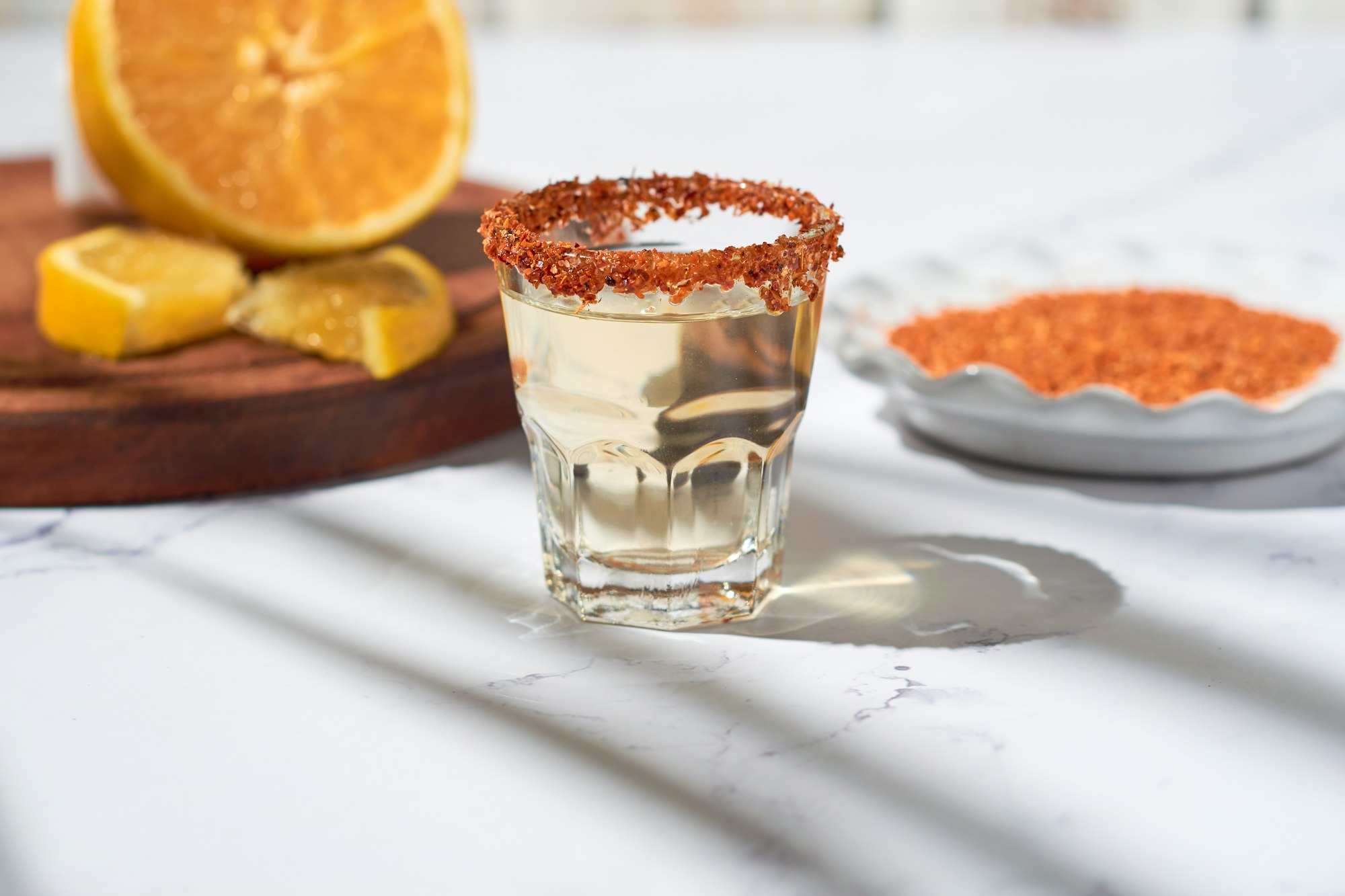 Mezcal shot mexican drink with orange slices and chili pepper